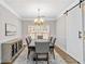 Elegant dining room with a modern chandelier and barn door, perfect for Gathering meals at 5775 Stephens Mill Dr, Sugar Hill, GA 30518