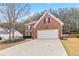 Classic brick home featuring a two-car garage and a neatly maintained front lawn at 5775 Stephens Mill Dr, Sugar Hill, GA 30518