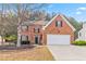 Charming two-story brick home with a two-car garage and a well-manicured front yard at 5775 Stephens Mill Dr, Sugar Hill, GA 30518
