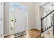 Bright foyer featuring hardwood floors, staircase, and natural light streaming through the front door at 5775 Stephens Mill Dr, Sugar Hill, GA 30518