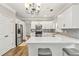 Bright kitchen features white cabinets, quartz countertops, stainless appliances, and bar stool seating at 5775 Stephens Mill Dr, Sugar Hill, GA 30518