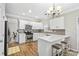 Charming kitchen boasts stainless steel appliances, stone backsplash, and an attached breakfast bar at 5775 Stephens Mill Dr, Sugar Hill, GA 30518