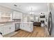 Beautiful kitchen with stainless steel appliances and backsplash open to a cozy living area with fireplace at 5775 Stephens Mill Dr, Sugar Hill, GA 30518