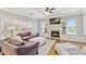 Cozy living room with a fireplace, built-in shelving, and comfortable seating arrangement at 5775 Stephens Mill Dr, Sugar Hill, GA 30518