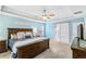 This main bedroom includes a wooden bed frame, tray ceilings, light blue walls, and an attached bathroom at 5775 Stephens Mill Dr, Sugar Hill, GA 30518