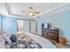 Bright main bedroom with a tray ceiling, ceiling fan, sliding barn door, and a large dresser at 5775 Stephens Mill Dr, Sugar Hill, GA 30518