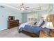 This main bedroom includes a large window, ceiling fan, dresser, and decorative furnishings at 5775 Stephens Mill Dr, Sugar Hill, GA 30518