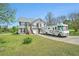 Charming two-story home featuring grey siding, white trim, front yard, RV parking, and well-manicured lawn at 1218 Cabots Ln, Auburn, GA 30011