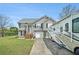 Charming two-story home featuring grey siding, white trim, front yard, RV parking, and well-manicured lawn at 1218 Cabots Ln, Auburn, GA 30011