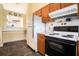 A charming kitchen featuring wood cabinets and modern white appliances and pass-through window at 1218 Cabots Ln, Auburn, GA 30011