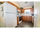 Functional kitchen featuring white appliances, wood cabinets, and vinyl flooring at 1218 Cabots Ln, Auburn, GA 30011