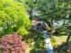 Aerial view of a home with a well-maintained lawn, mature trees, and a covered front porch at 1629 Anita Ne Pl, Atlanta, GA 30306