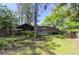 Landscaped backyard boasts lush greenery, mature trees, wooden deck with lattice fence, and privacy fence at 1629 Anita Ne Pl, Atlanta, GA 30306