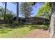 Serene backyard featuring mature trees, a well-manicured lawn, and a cozy deck with lattice fence at 1629 Anita Ne Pl, Atlanta, GA 30306