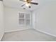 Simple bedroom with a window for natural light, neutral carpeting, and a ceiling fan for comfort at 2155 Washington Dr, Douglasville, GA 30135