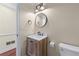 A well-lit half-bathroom with neutral walls and a sink and toilet and modern fixtures at 2804 Livsey Woods Dr, Tucker, GA 30084