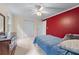 This cozy bedroom includes a closet, neutral carpet, ceiling fan, and red accent wall at 2804 Livsey Woods Dr, Tucker, GA 30084