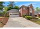 Beautiful brick home with an attached garage, long driveway, and manicured landscaping at 2804 Livsey Woods Dr, Tucker, GA 30084