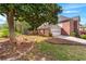 Brick home featuring a two-car garage, landscaped yard, and a charming stone bench by a large tree at 2804 Livsey Woods Dr, Tucker, GA 30084