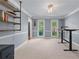 An office space with two windows, gray walls, and an adjustable desk with an attached bookshelf at 2804 Livsey Woods Dr, Tucker, GA 30084
