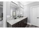 Bright bathroom boasts a dual sink vanity with granite countertop, dark cabinets, and modern lighting fixtures at 2528 Magnolia Ridge Dr, Marietta, GA 30067