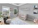 A serene Bedroom with a white crib, modern decor, and ample natural light from two windows at 2528 Magnolia Ridge Dr, Marietta, GA 30067