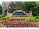Stone entrance sign to 'The Oaks' surrounded by colorful flowers and lush greenery at 2528 Magnolia Ridge Dr, Marietta, GA 30067