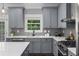 This kitchen has gray cabinets, stainless steel appliances, quartz countertops, a subway tile backsplash and a window at 2528 Magnolia Ridge Dr, Marietta, GA 30067