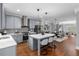 This kitchen has an island with seating, gray cabinets, stainless steel appliances, quartz countertops, and hardwood floors at 2528 Magnolia Ridge Dr, Marietta, GA 30067