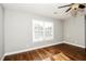 Bright bedroom featuring hardwood floors, a ceiling fan, and a window for natural light at 6331 Wedgeview Dr, Tucker, GA 30084