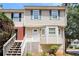 Inviting townhouse with vinyl siding and a quaint front porch with white rails and a staircase at 6331 Wedgeview Dr, Tucker, GA 30084