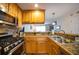 A kitchen featuring wood cabinets, stainless steel appliances, and granite countertops with a view into the living area at 2232 Dunseath Ave # 407, Atlanta, GA 30318