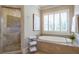 Elegant bathroom featuring soaking tub with tile surround, walk-in shower, and plantation shutters at 854 Club Moss Ct, Marietta, GA 30068