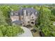 Stately stone-clad home with a porte-cochere and lush landscaping, offering timeless elegance and curb appeal at 854 Club Moss Ct, Marietta, GA 30068