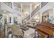 Open concept living room with grand piano, staircase, and elegant furnishings bathed in natural light at 854 Club Moss Ct, Marietta, GA 30068