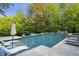 Backyard pool with waterfall feature, surrounded by lush landscaping and lounge chairs at 854 Club Moss Ct, Marietta, GA 30068
