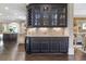 Elegant wet bar with custom cabinetry, wine cooler, glass shelving, and granite countertops at 854 Club Moss Ct, Marietta, GA 30068