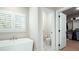 Bright bathroom featuring a modern soaking tub, shuttered windows, and access to a walk-in closet at 920 Wemberley Ln, Marietta, GA 30064