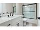 Well-lit bathroom with a white vanity, black fixtures, and a glass-enclosed shower at 920 Wemberley Ln, Marietta, GA 30064