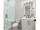 Bathroom with white vanity, marble floors, toilet, and glass enclosed shower with built-in bench at 920 Wemberley Ln, Marietta, GA 30064