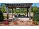 Outdoor fire pit with overhead pergola surrounded by landscaping, creating a charming gathering spot at 920 Wemberley Ln, Marietta, GA 30064