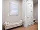 Hallway nook with wooden floors and a plush white storage bench by a sunny window at 920 Wemberley Ln, Marietta, GA 30064