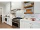 Modern kitchen with stainless steel appliances, stone countertops, floating shelves, and white subway tile backsplash at 920 Wemberley Ln, Marietta, GA 30064