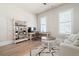 Well-lit home office with neutral decor, wooden floors, white plantation shutters, and shelving at 920 Wemberley Ln, Marietta, GA 30064
