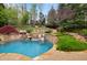 Backyard features a rock waterfall, stone landscaping, and a nearby pool and lounge area at 1319 Glen Cedars Dr, Smyrna, GA 30126