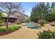 An elevated view of a backyard with a swimming pool, spa, wooden pavilion, lush landscaping, and mature trees at 1319 Glen Cedars Dr, Smyrna, GA 30126