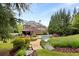 Wide angle backyard showing swimming pool, landscaping, patio, and large luxury home with trees and lawn at 1319 Glen Cedars Dr, Smyrna, GA 30126
