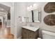 Well-lit half bathroom with a large framed mirror and decorative wall hangings at 1319 Glen Cedars Dr, Smyrna, GA 30126