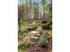 A backyard with stone steps, rock wall and retaining wall, lawn, landscaping, and mature trees at 1319 Glen Cedars Dr, Smyrna, GA 30126