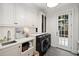 Bright laundry room featuring new appliances and ample cabinet space at 1319 Glen Cedars Dr, Smyrna, GA 30126